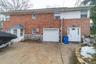Rear view of property with a garage, driveway, and brick siding