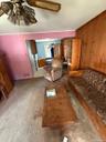 Living room featuring wooden walls, carpet, and a ceiling fan