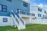 Back of house featuring stairway, a lawn, and a wooden deck
