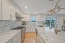 Kitchen featuring stainless steel appliances, under cabinet range hood, plenty of natural light, white cabinets, and recessed lighting