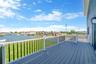 Wooden terrace featuring a lawn and a water view