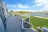 Wooden deck featuring a water view and a yard