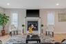 Living room featuring healthy amount of natural light, a glass covered fireplace, wood finished floors, and recessed lighting