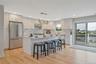 Kitchen featuring appliances with stainless steel finishes, under cabinet range hood, light wood-style flooring, tasteful backsplash, and a kitchen ba