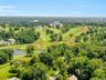 This aerial shot captures the expansive, verdant fairways of the Westchester Country Club, centered by its grand historic clubhouse. 19 PDS is situate