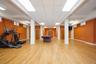 Spacious basement with a stage area, two bathrooms, one shower, a utility room, and a large storage room, offering flexible space for a variety of use