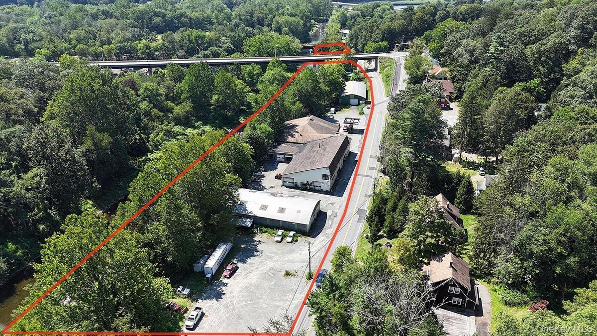 Aerial overview of property's location with property parcel outlined and a heavily wooded area
