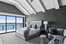 Bedroom with access to exterior, high vaulted ceiling, and a water view