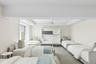 Bedroom with ceiling fan, a raised ceiling, and wallpapered walls