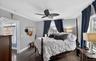 Bedroom with ornamental molding, dark wood-style floors, and ceiling fan