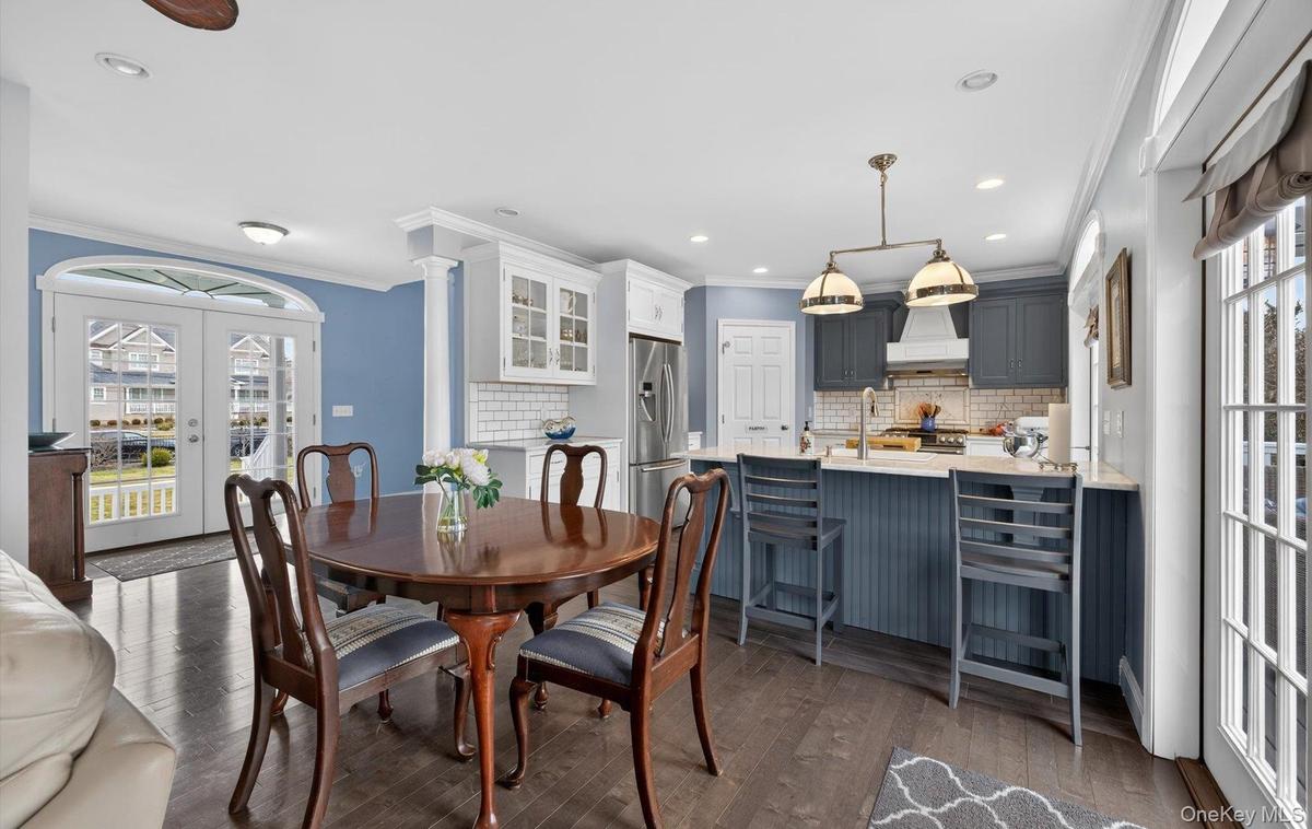 Dining area featuring french doors, crown molding, dark wood-style floors, and recessed lighting
