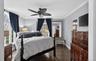 Bedroom featuring crown molding, dark wood-type flooring, and a ceiling fan