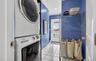 Laundry area with light tile patterned floors, stacked washer and dryer, crown molding, and recessed lighting