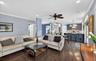 Living room featuring ornamental molding, a ceiling fan, dark wood-style flooring, recessed lighting, and decorative columns