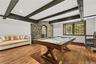 Sophisticated timber beams and a custom stonework accent wall frame a private, temperature-controlled wine cellar. This refined billiards lounge offer