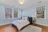 Bedroom featuring detailed molding and wood finished floors.