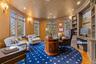 Sophisticated home office featuring a curved wall of stunning stained-glass windows that fill the space with natural light and architectural charm. Cu