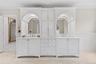 Bathroom with a decorative wall, wainscoting, double vanity, light tile patterned floors, and inlaid floor details