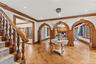 Entryway with arched walkways, detailed molding, parquet flooring, a warm lit fireplace, and recessed lighting