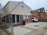 View of front of house with cooling unit, brick siding, and fence private yard