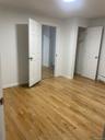 Unfurnished bedroom with light wood-style flooring, a closet, and a baseboard heating unit