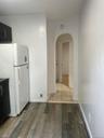 Kitchen with freestanding refrigerator, light wood-style floors, and arched walkways