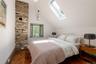 Bedroom with hardwood / wood-style floors, a skylight, and vaulted ceiling