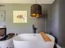 Bathroom featuring a freestanding tub, vanity, and baseboards