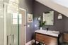 Bathroom with vanity, a shower with shower door, baseboards, and vaulted ceiling