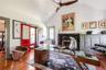 Office featuring lofted ceiling, hardwood / wood-style flooring, a fireplace, and a ceiling fan