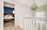 Corridor featuring a chandelier, hardwood / wood-style floors, and a healthy amount of sunlight