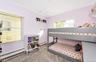 Bedroom with wood-type flooring, crown molding, a baseboard heating unit, and a notable chandelier