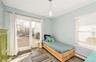 Bedroom with dark hardwood / wood-style floors, ornamental molding, access to outside, and a baseboard heating unit