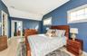 Bedroom with light hardwood / wood-style floors and lofted ceiling