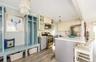 Kitchen with appliances with stainless steel finishes, tasteful backsplash, light hardwood / wood-style flooring, a center island, and hanging light f