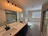 Bathroom with a garden tub, double vanity, a marble finish  with separate shower, and plenty of natural light