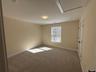Empty room featuring light carpet and attic access