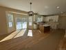 Kitchen featuring hanging lights, white cabinetry, light wood finished floors, and a kitchen island