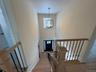 Stairway with suspended lighting, wood finished floors, and a high ceiling