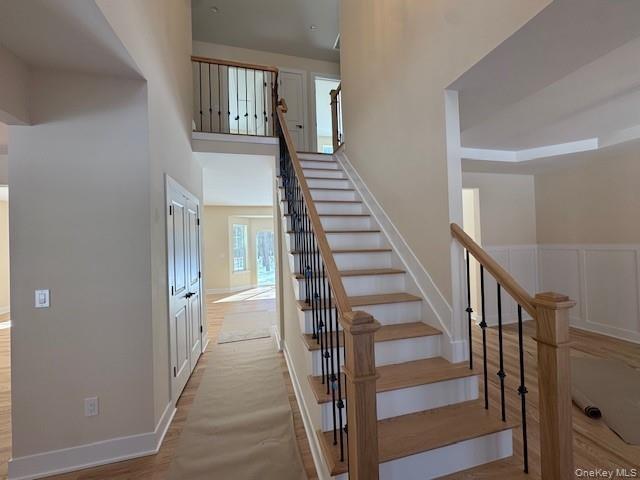 Stairway with a high ceiling and wood finished floors