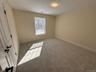 Unfurnished bedroom with light colored carpet