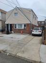View of front of property with cooling unit, brick siding, and driveway