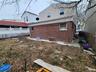 Rear view of property with brick siding and fence