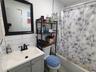 Full bath with shower / tub combo with curtain, toilet, tasteful backsplash, tile walls, and vanity