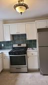 Kitchen with white cabinetry, light countertops, tasteful backsplash, and stainless steel appliances