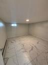 Below grade area with baseboards and marble finish floor