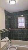 Full bathroom with tile walls, shower / washtub combination, toilet, and vanity