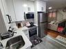 Kitchen featuring white cabinetry, light countertops, decorative backsplash, and stainless steel appliances