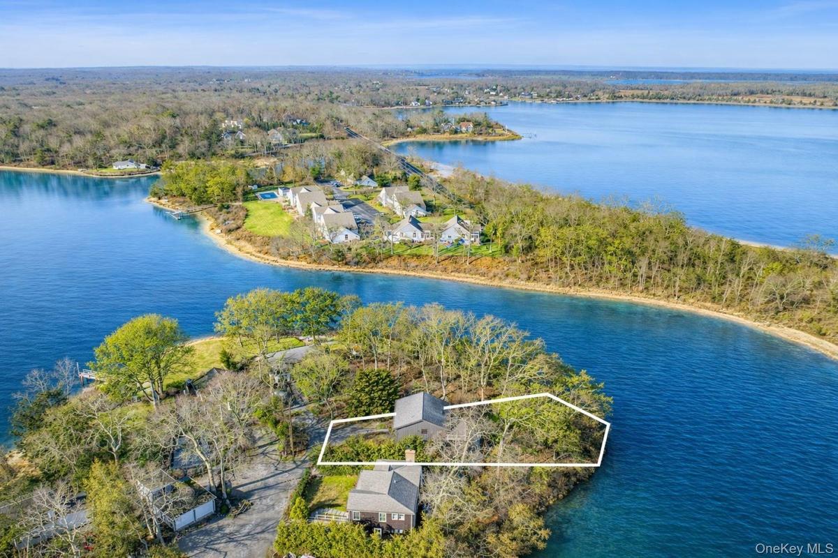 Aerial view of property and surrounding area featuring property boundaries highlighted and a nearby body of water