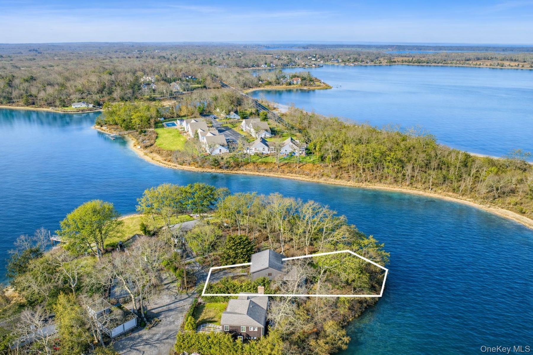 Aerial view of property and surrounding area featuring property boundaries highlighted and a nearby body of water
